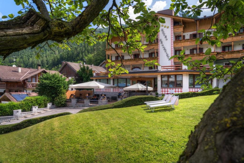a hotel with a green lawn in front of a building at Hotel Bellavista in Pinzolo
