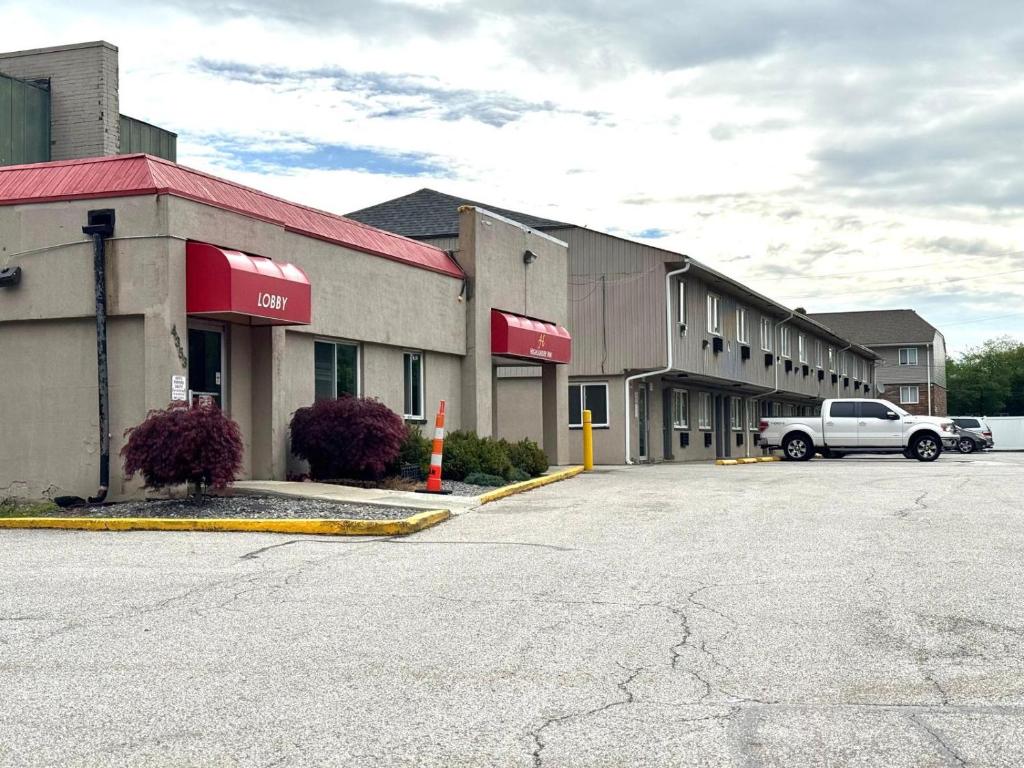 a building with a truck parked in a parking lot at Highlander Inn Cleveland Beachwood Near I-480 in North Randall