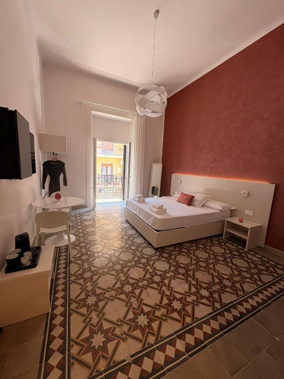 a bedroom with a bed and a rug on the floor at Casa Blanca Rooms&Suites in Reggio di Calabria