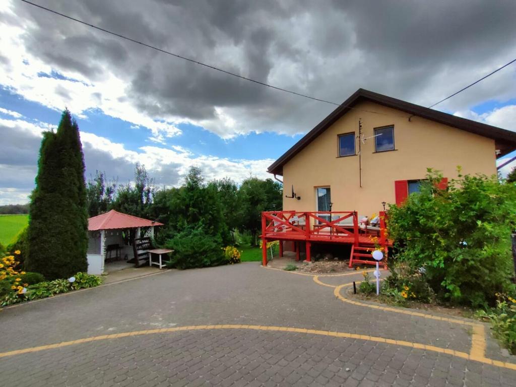 a house with a red bench in front of it at Sielskie Markowskie in Markowskie