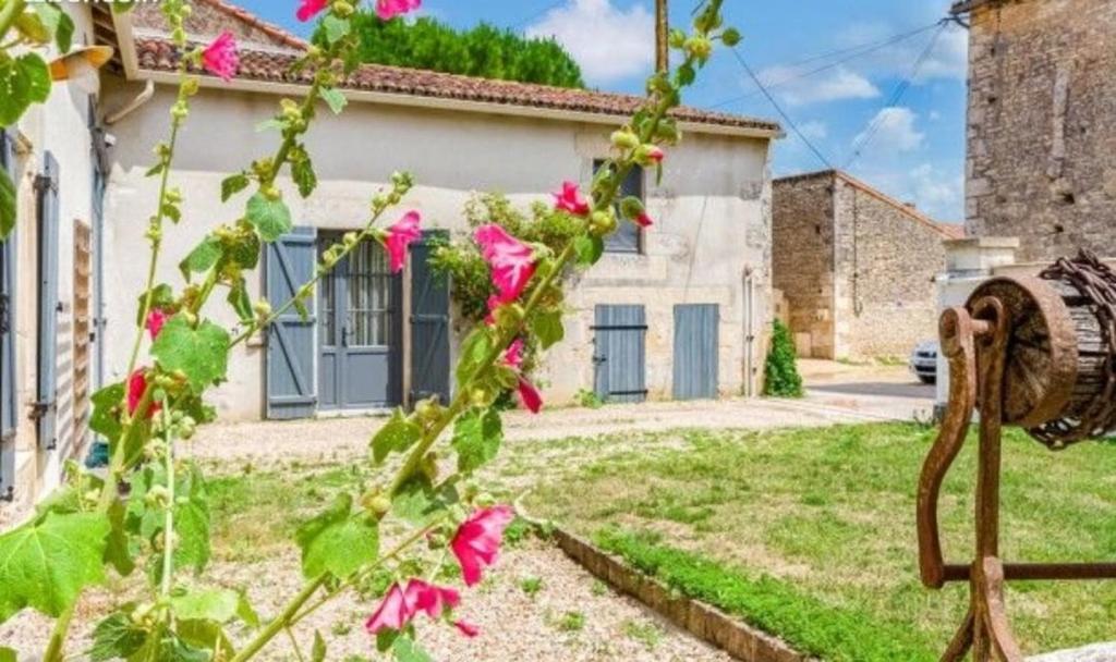 a house with pink flowers in front of it at Gîte in Avanton