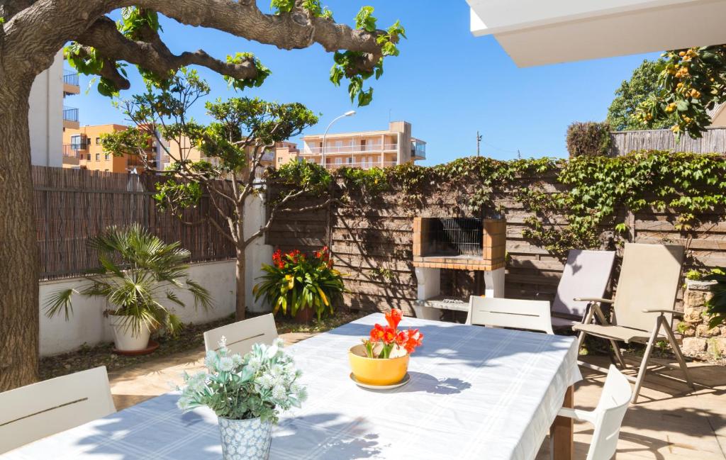 a table with chairs and flowers on a patio at Villa Paula Trinidad in Salou