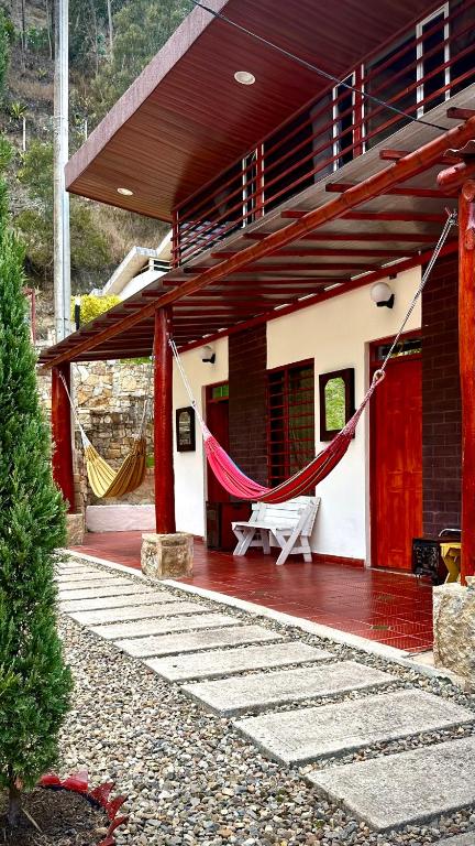a house with a porch with a hammock in it at MONTESANO Finca HOTEL in Jenesano