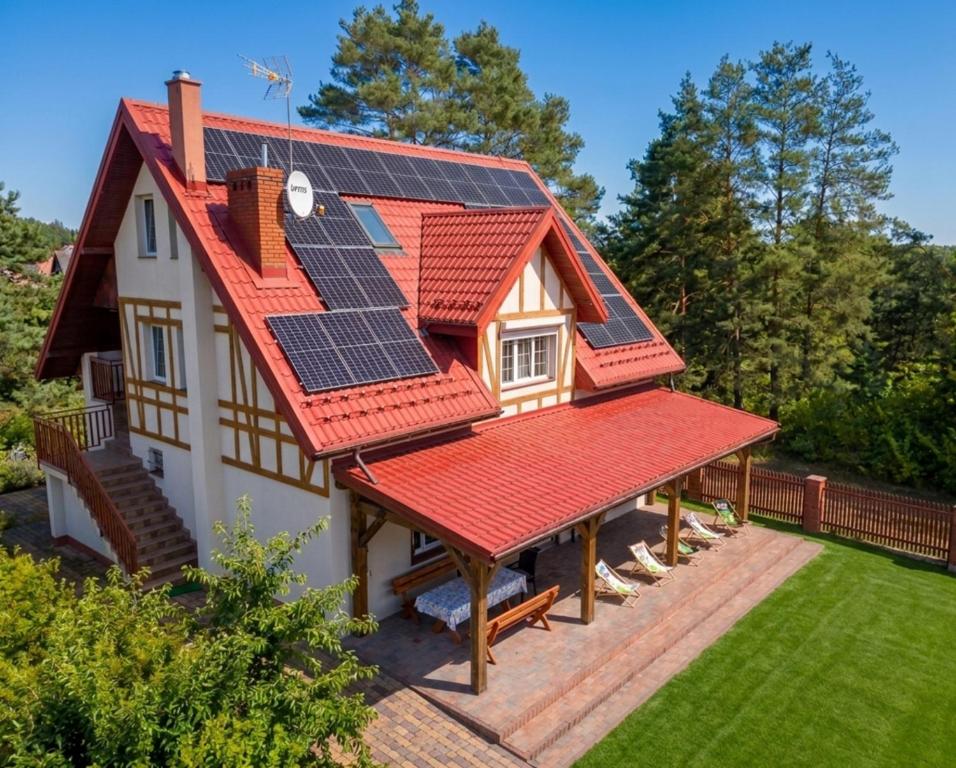 a house with solar panels on its roof at Mazury Villa Ecomfort in Szeligi