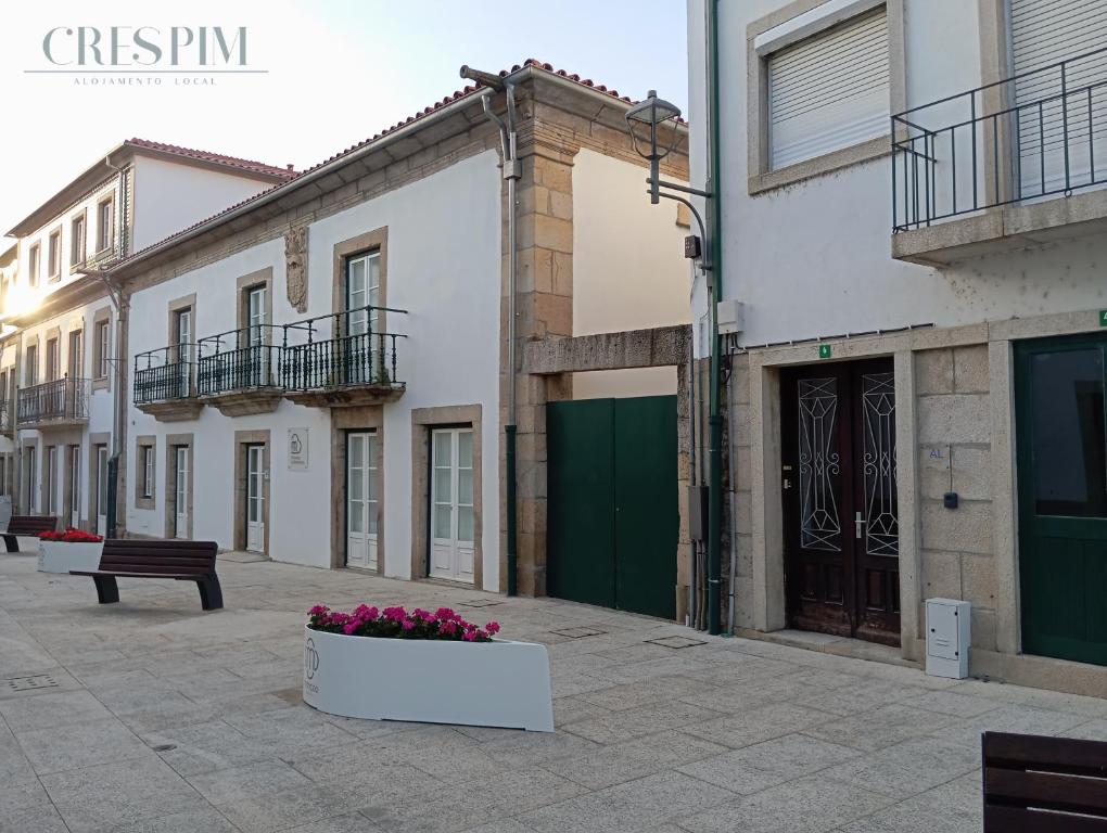 a row of buildings on a street with a bench at Casa Crespim in Monção