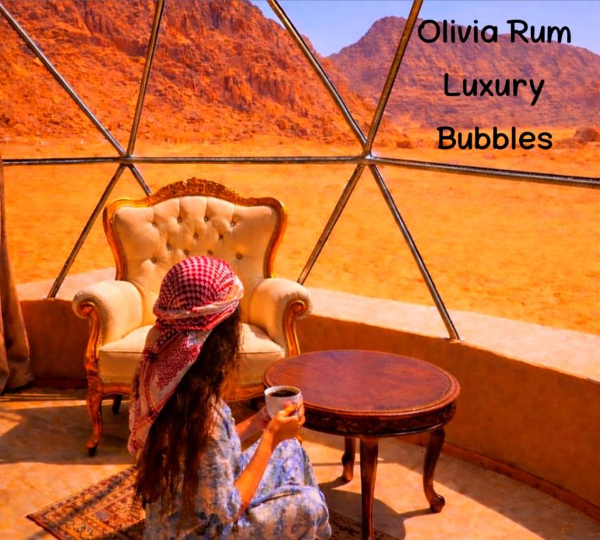 a young girl sitting in a room with a table at Olivia Rum Luxury Bubbles & Jeep Tours in Wadi Rum