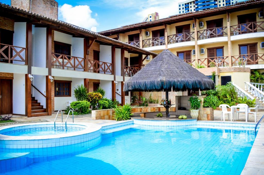 a swimming pool in front of a hotel at O Tempo e o Vento in Natal