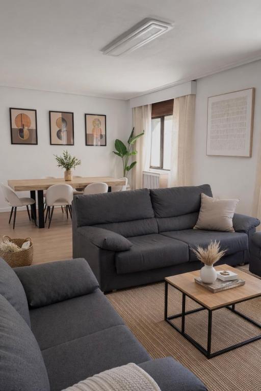 a living room with a blue couch and a table at Entre Plazas in Cáceres