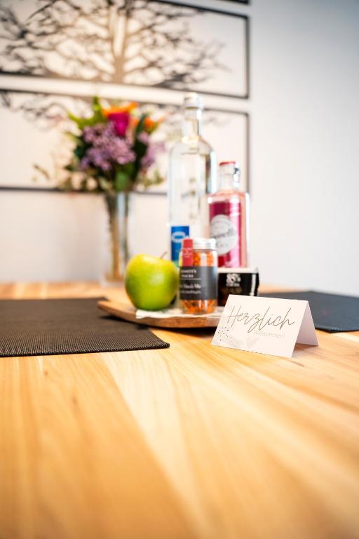 a table with a plate of fruit and a bottle of alcohol at Ferienwohnung RaiKa in Moers