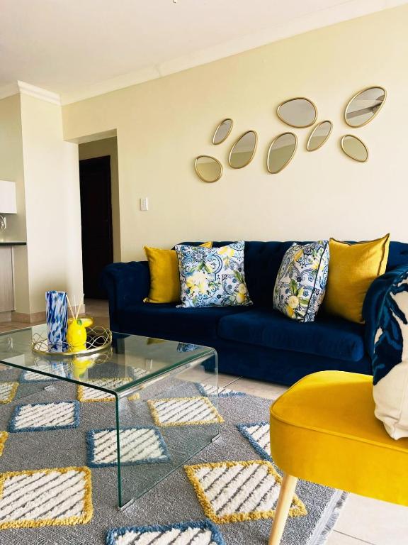 a living room with a blue couch and a table at 15 Surabaya in Margate