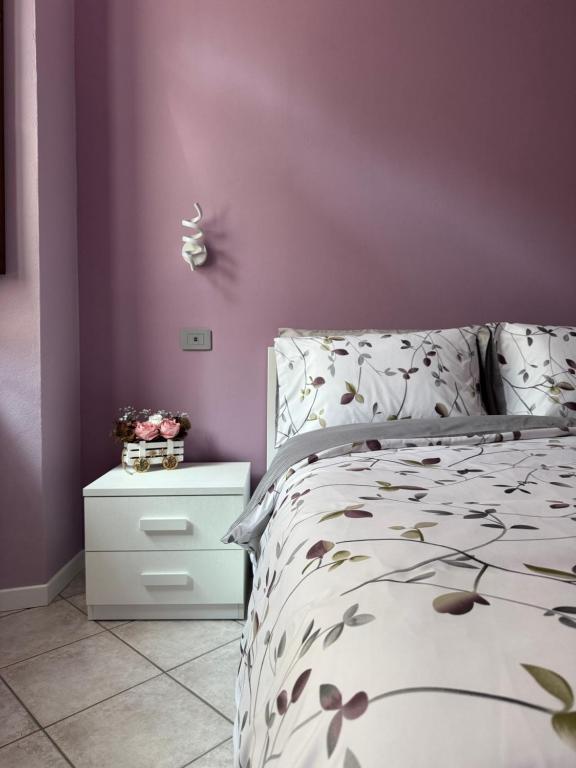 a bedroom with a bed and a purple wall at Le Scuderie - casa vacanze in Intra