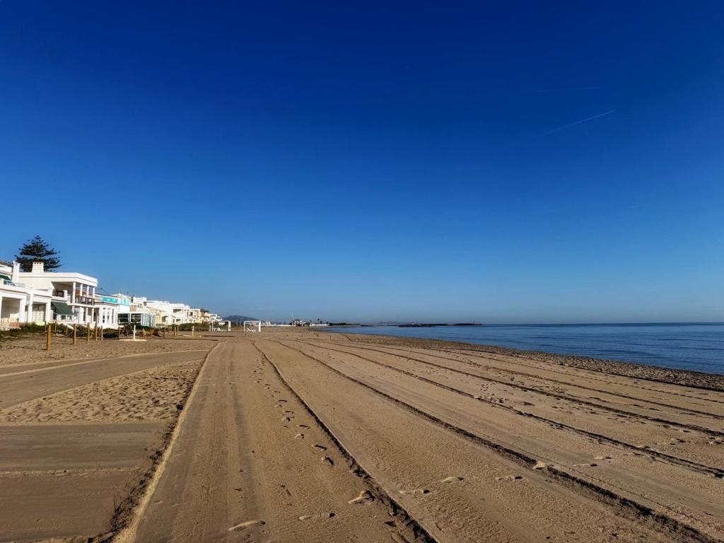 a sandy beach with houses and the ocean at Oliva Seaside Apartments in Oliva