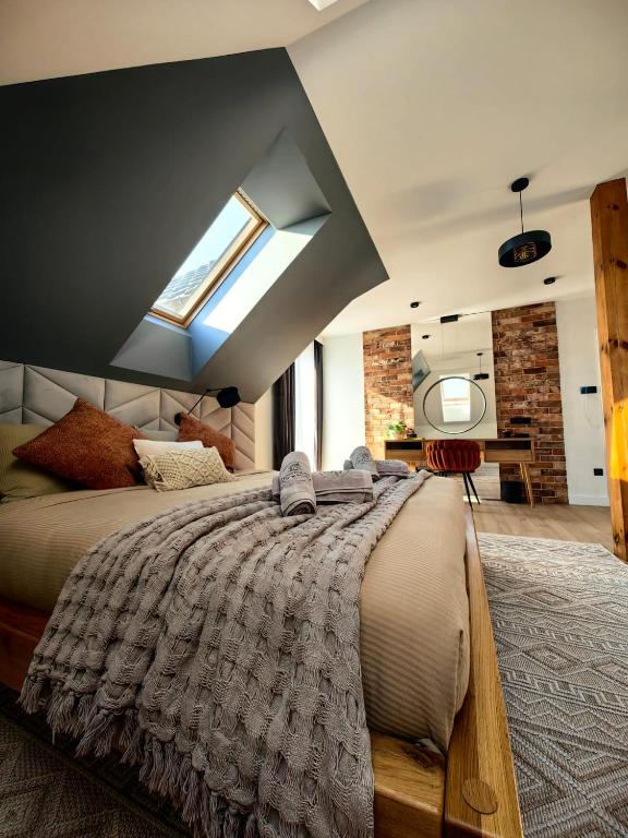 a bedroom with a large bed with a window at Loft Haven - Loftowa Przystań in Trzemeszno