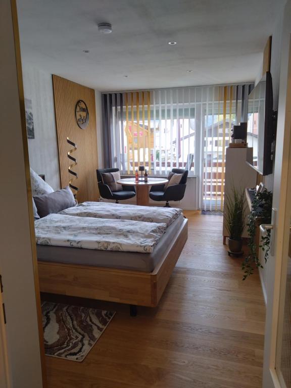 a bedroom with a bed and a table and chairs at Goldstück in Oberstdorf