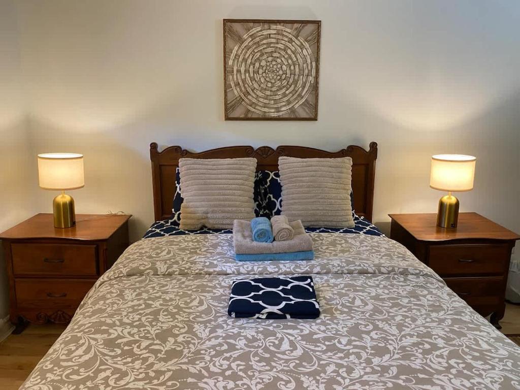 a bedroom with a bed with two lamps and towels at Luxury comforts getaway home in Brossard