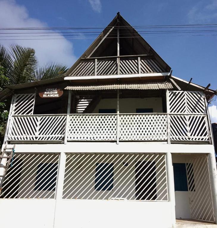 a white building with a pointed roof at Chalé Maison Blanche in Maracanã