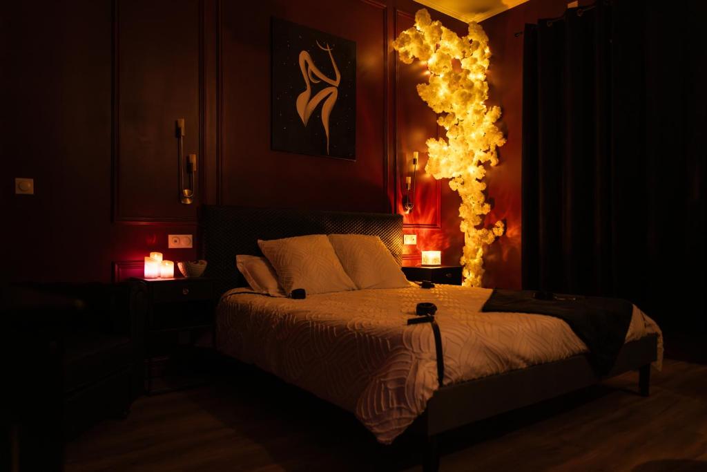 a bedroom with a bed with lights on the wall at Suite romantique avec Balneo et jeux coquins in Roanne