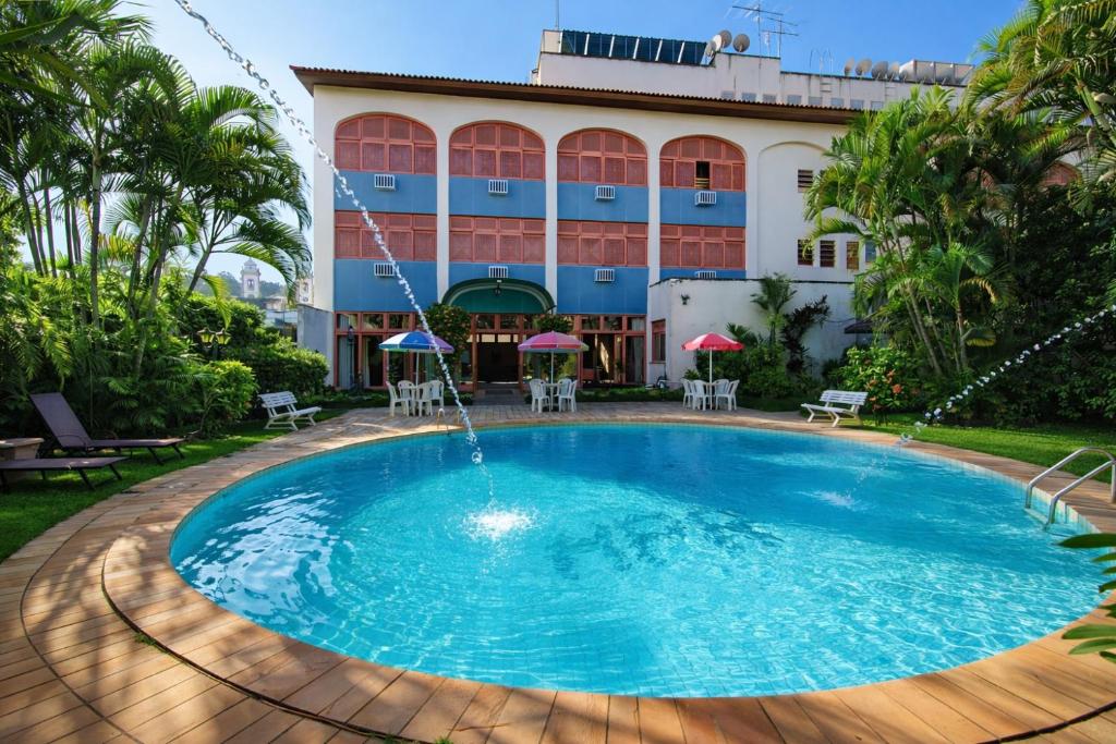 a swimming pool in front of a building at Hotel Ponte Real in São João del Rei