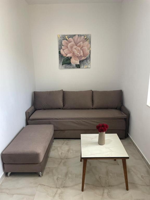 a living room with a couch and a table at Santorini Drimadh Apartment in Gjilek