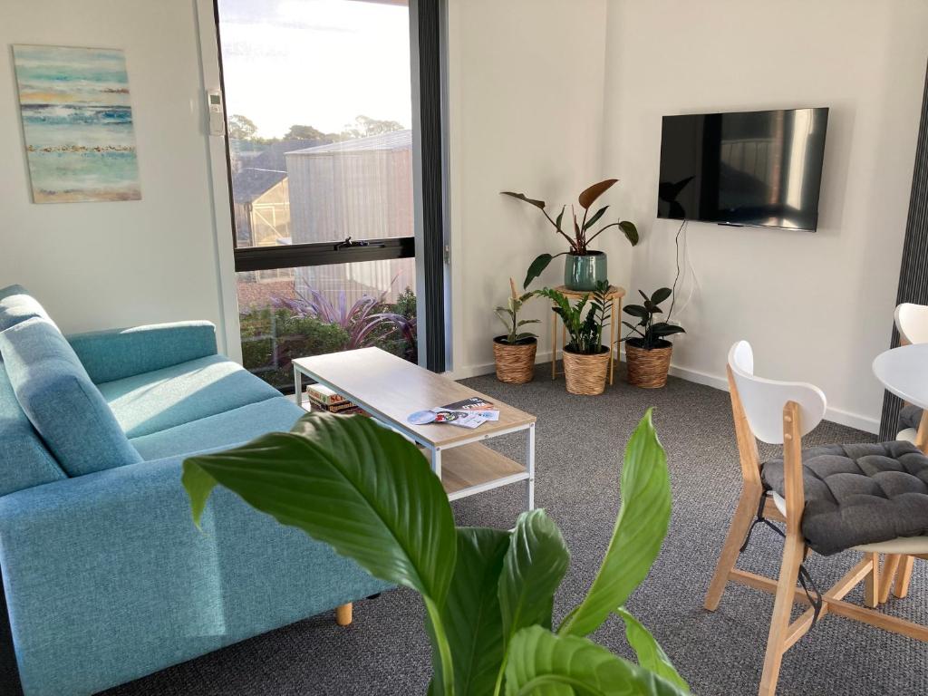 a living room with a blue couch and potted plants at George Town Central Apartment in George Town