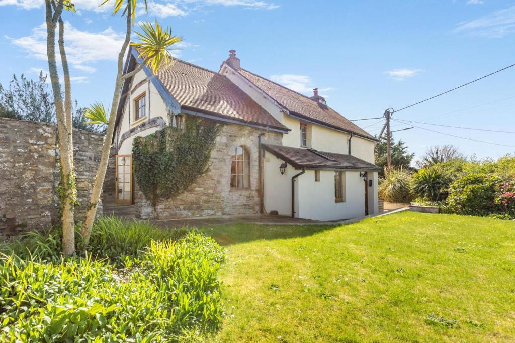 an old stone house with a palm tree in the yard at 3 Bed in Croyde oc-s27761 in Croyde