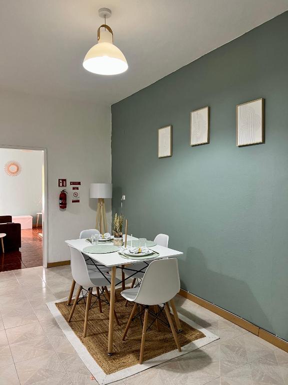 a dining room with a white table and chairs at Meu Quintal 4, Calheta-Madeira in Calheta