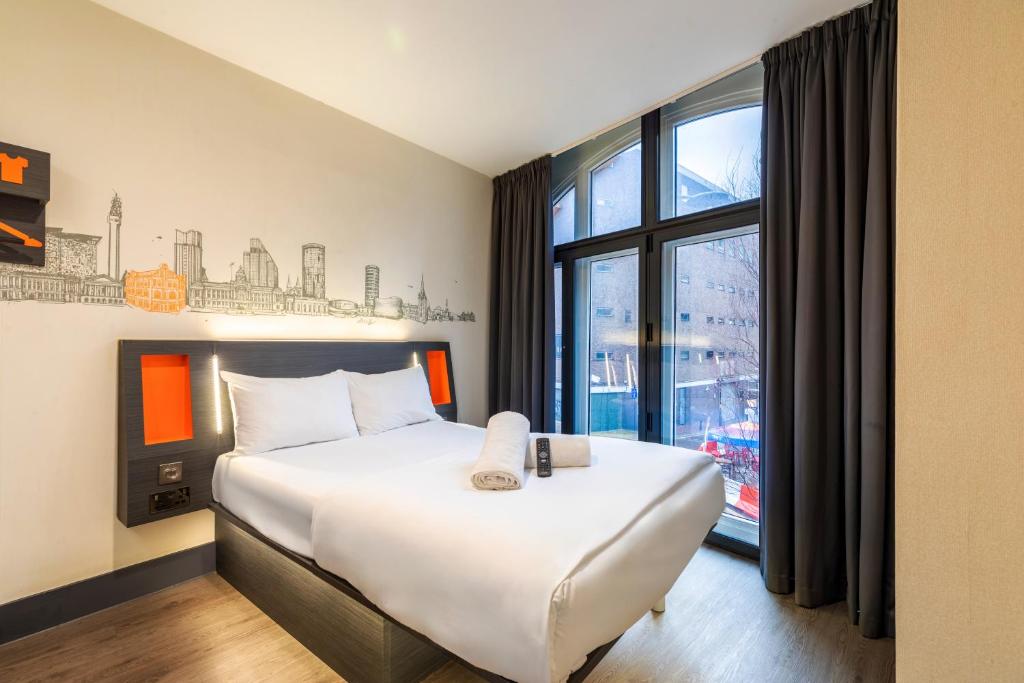 a hotel room with a bed and a large window at easyHotel Birmingham in Birmingham