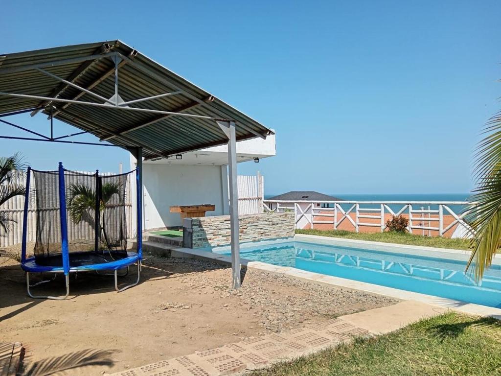 a pavilion next to a swimming pool with a swing at VistamarGrau in Caleta Grau