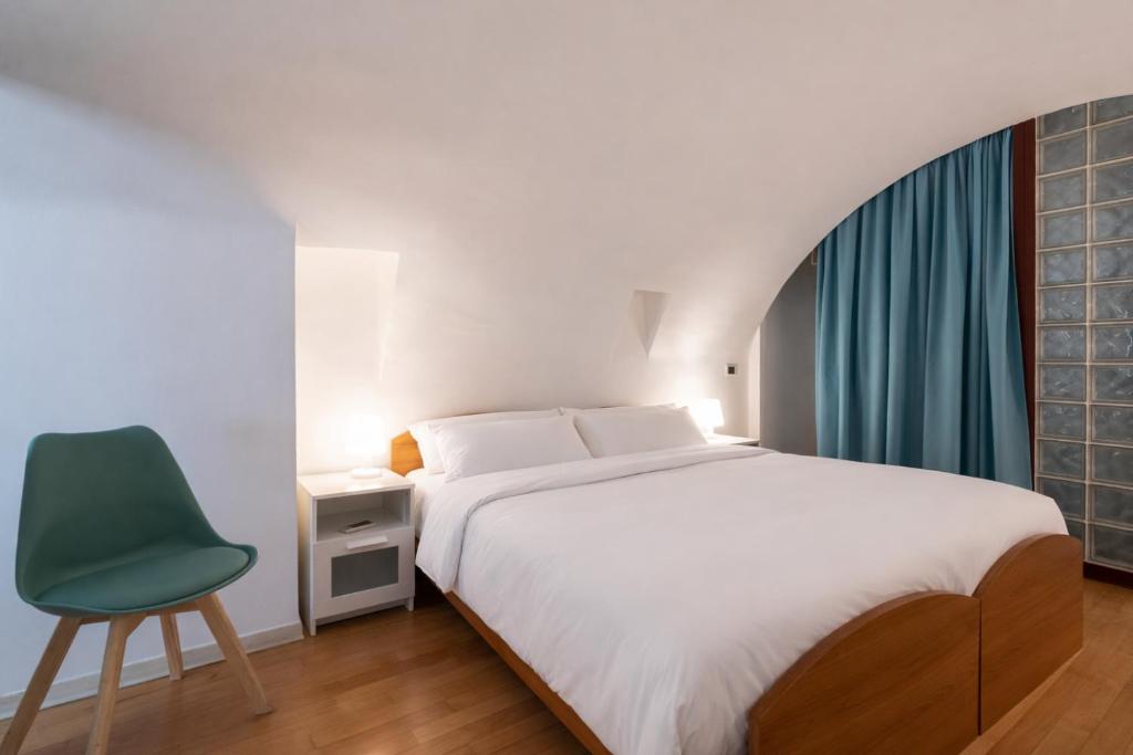 a bedroom with a bed and a green chair at Palazzo Barone in Bari
