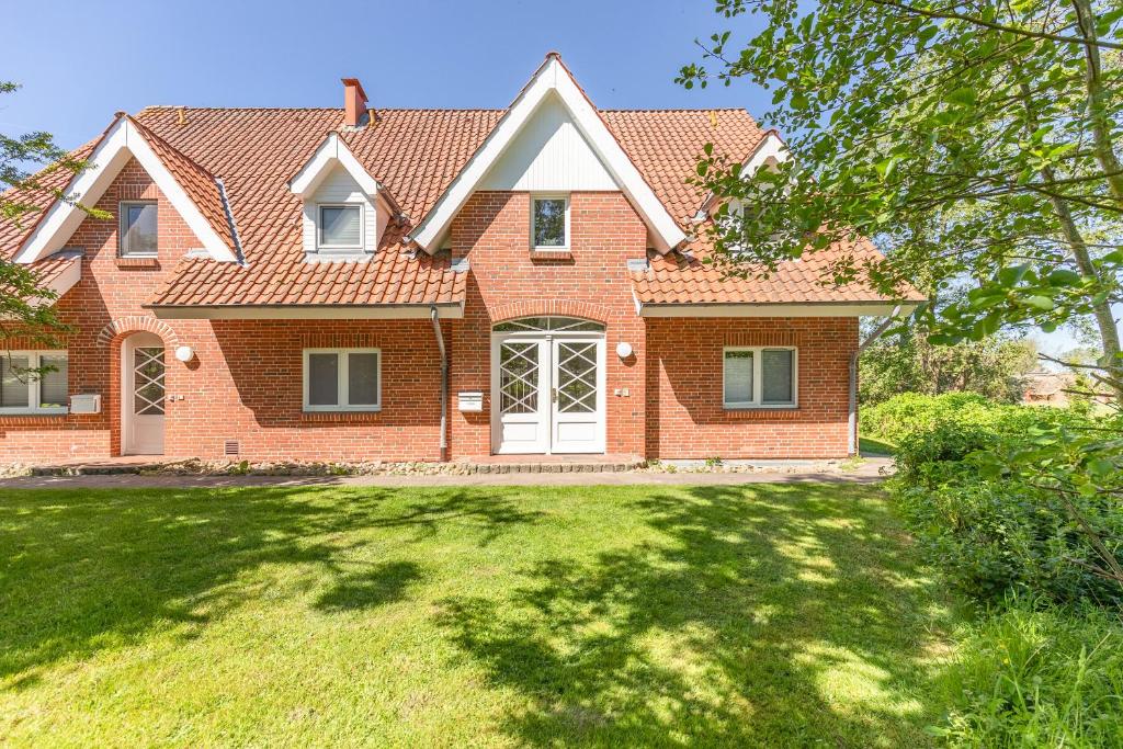 a red brick house with a grass yard at Westmarkenpalais in Böhl