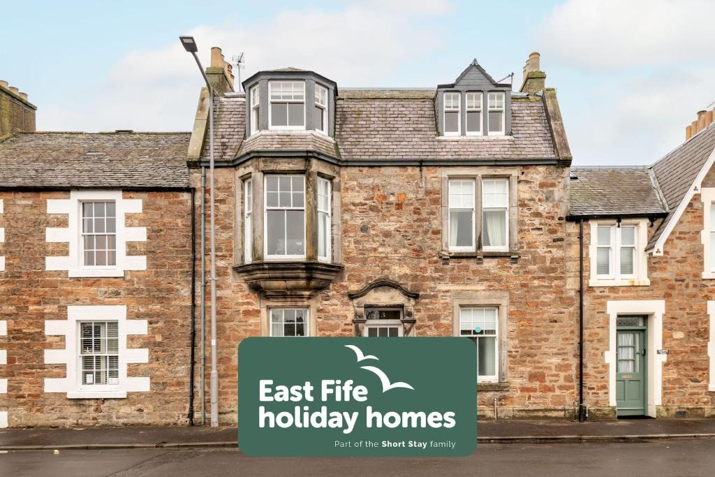 an image of a house with an east fire holiday homes sign in front at Church View - Elie in Elie