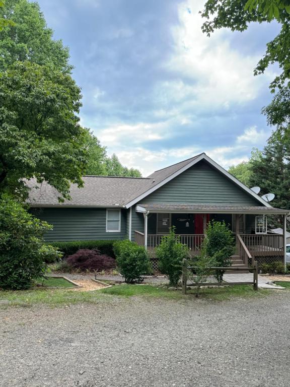 a house with a porch and a yard at Serenity Cove in Hiawassee