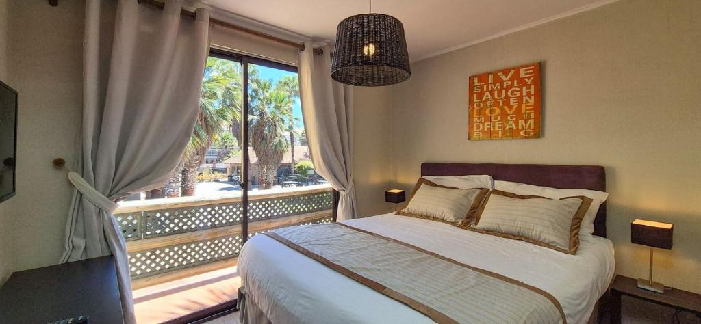 a bedroom with a bed and a large window at Apart Hotel Gran Pacifico in La Serena