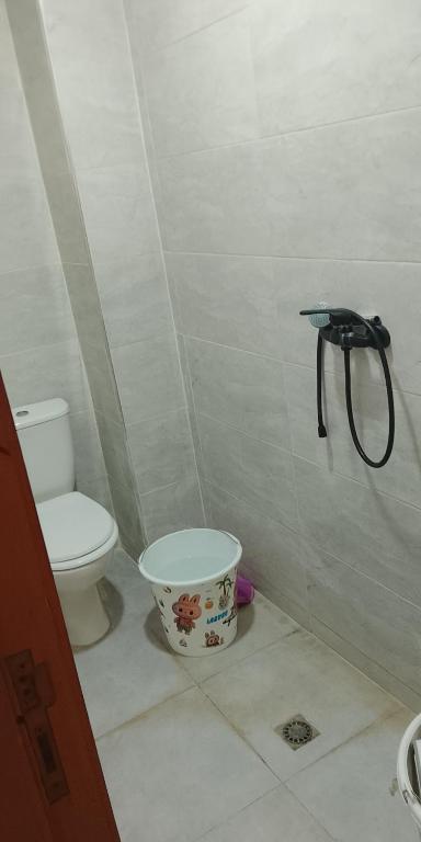 a bathroom with a toilet and a bucket at Amir's home in Meknès