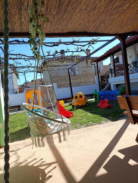 a swing in a yard with a playground at Rooster Retreat in Aridaia
