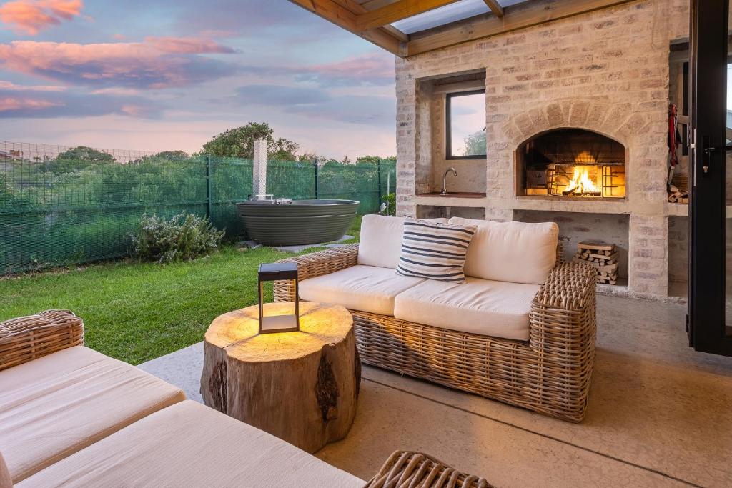 a living room with a couch and a fireplace at Modern Coastal Retreat - Private Hot Tub & Sauna in Hermanus
