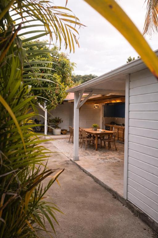 a patio with a table and a building at Coco'Living - Gîtes de standing partagés in Gourbeyre