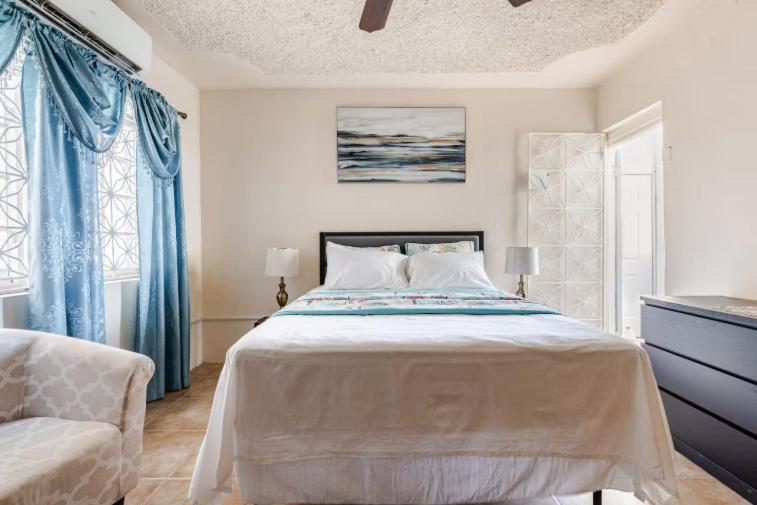 a bedroom with a large bed and a chair at Oceanview Retreat in Bull Bay