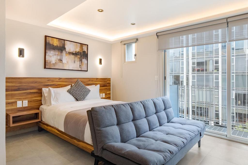 a bedroom with a bed and a couch at Guadalupe Inn in Mexico City