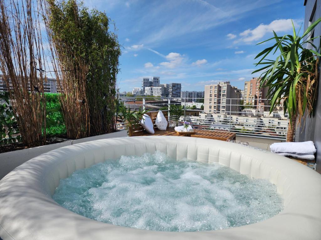 a hot tub on a balcony with a view of a city at Penthouse 166 m2- Terrasse & Parking - Paris Sud - Orly - Parc Expo in Bagneux