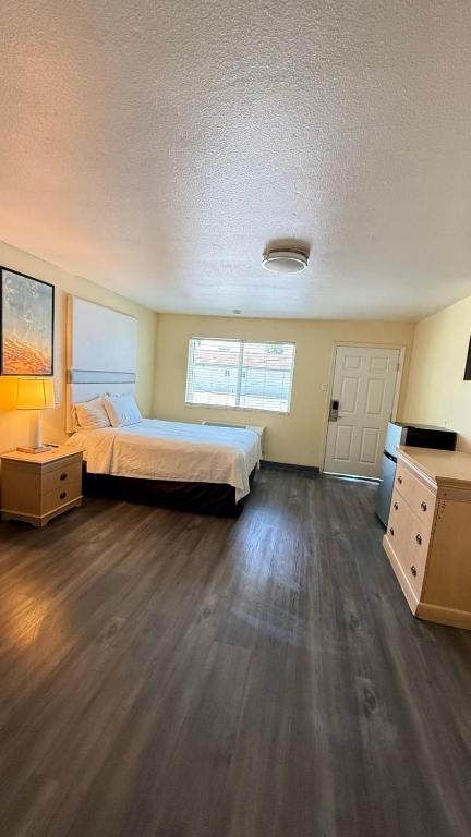 a large bedroom with a bed and a wooden floor at Citrus Inn & Suites in Porterville