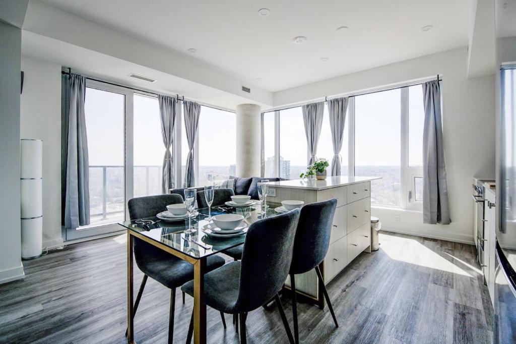 a dining room with a table and chairs and windows at Open concept with city views in Kitchener