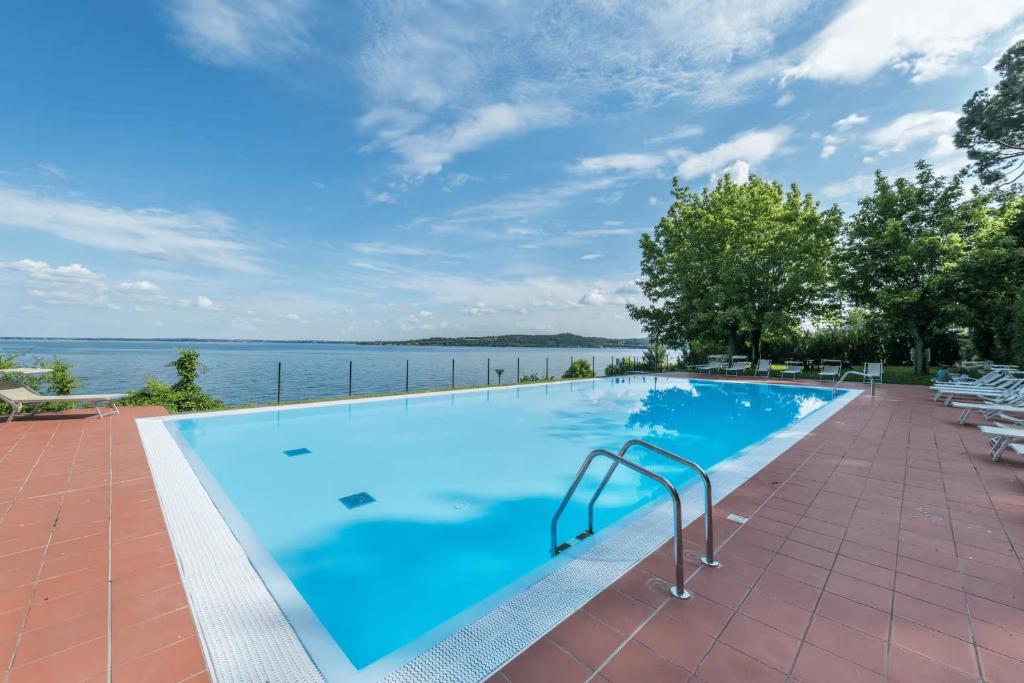 a swimming pool with a view of the water at MGH- Lake Serenity Apartment in Padenghe sul Garda