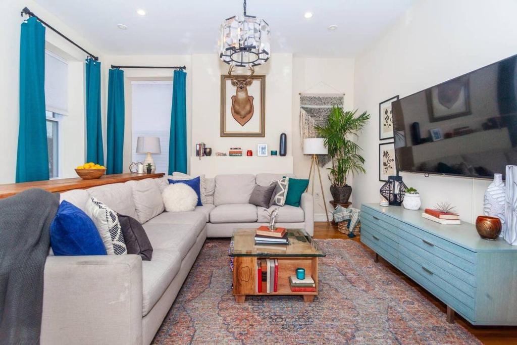 a living room with a couch and a tv at Expansive Essential Triplex near T in Boston