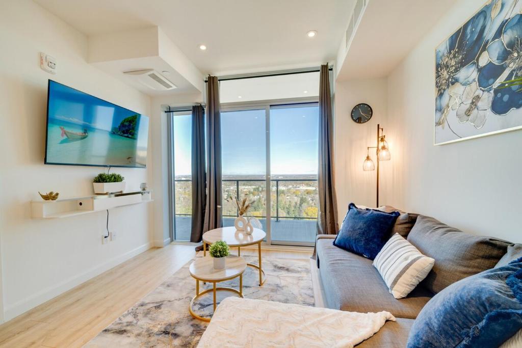 a living room with a couch and a large window at Modern Penthouse in Central KW in Kitchener