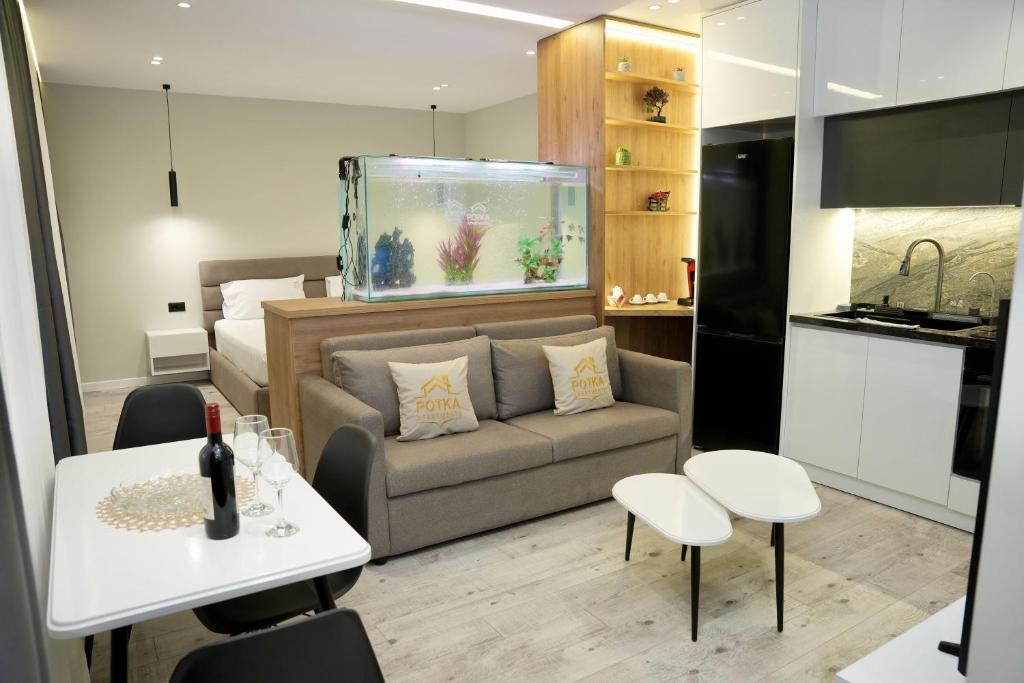a living room with a couch and a fish tank at Potka Apartments Tirane in Yzberishti