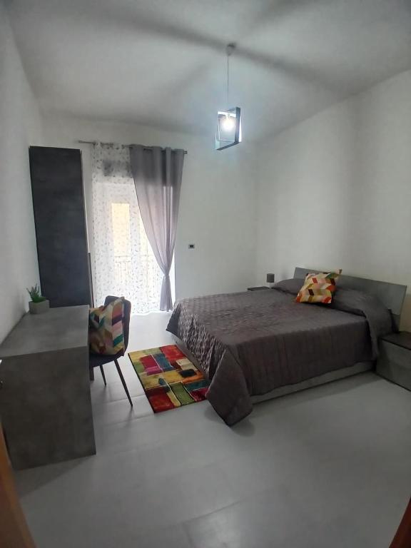 a bedroom with a bed and a chair and a window at Victoria Home in Eboli