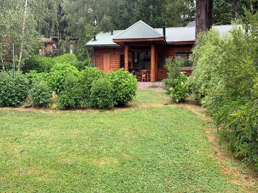 a log cabin with a yard in front of it at Cabaña Castaño in Villarrica
