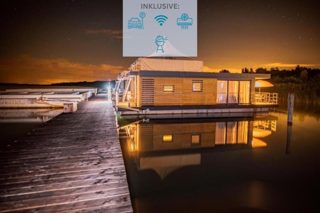 a house on a dock on the water at night at Floatinghouse Grasshopper in Klitten