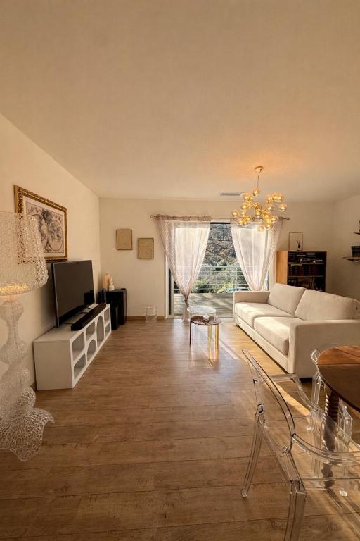 a living room with a white couch and a tv at Entire house 6 guests Mountain view in Luri